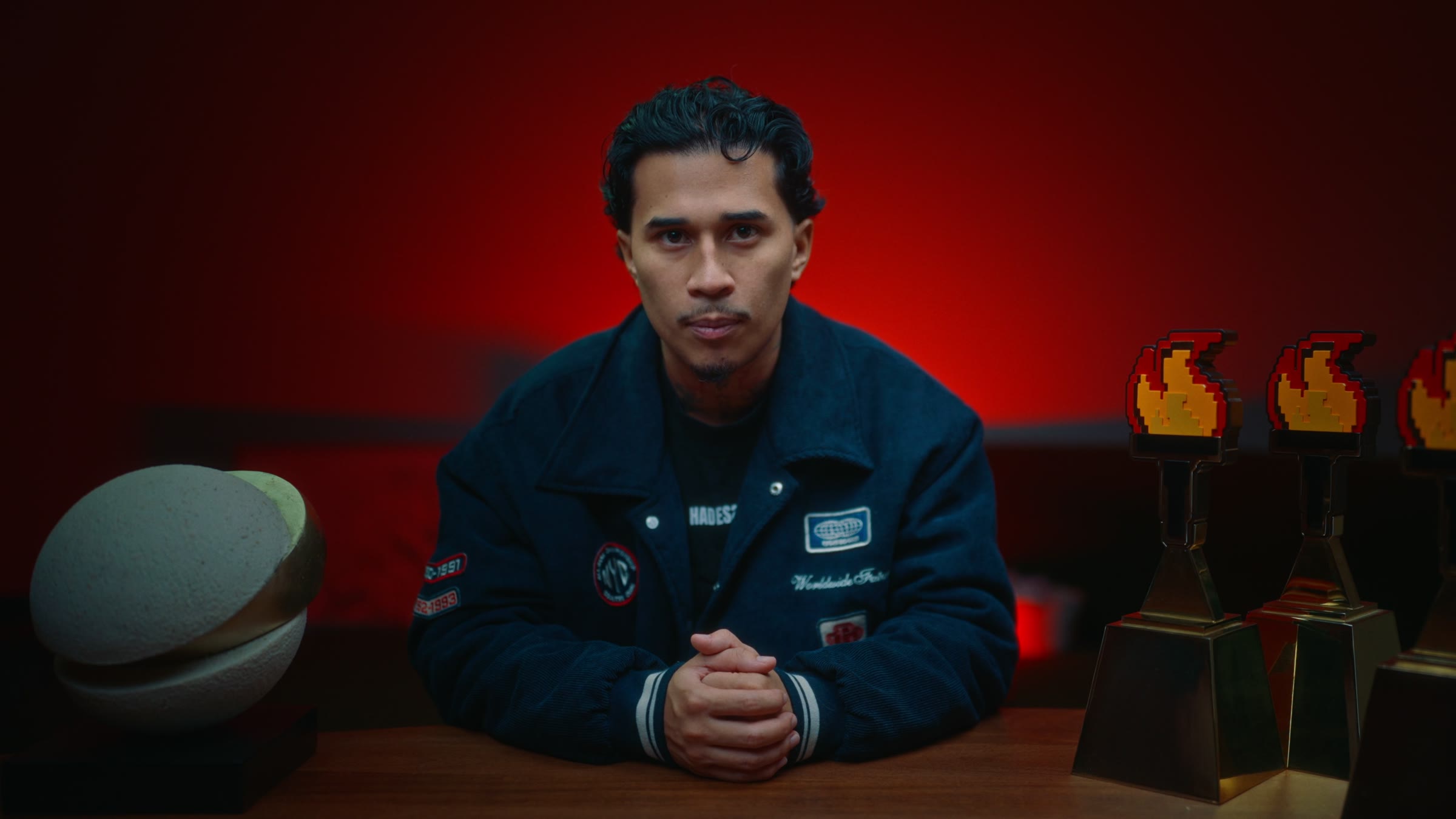 Anthony Sirius assis à son bureau, fond rouge